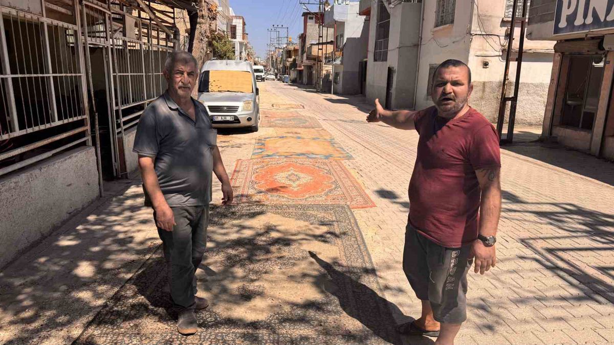 Tozdan bunalan mahalleli çareyi sokağa halı sermekte buldu
